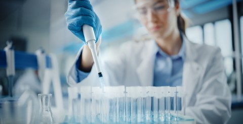 Porträt einer Wissenschaftlerin mithilfe einer Micro Pipette für die Testanalyse in einem Labor