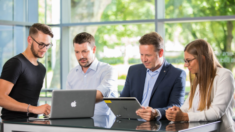 Personengruppe mit Laptop und Tablet